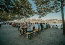 Mensen zitten op het grasveld en luisteren naar muzikanten op een klein podium © Koblenz-Touristik, Janko.Media
Mensen zitten op het grasveld en luisteren naar muzikanten op een klein podium © Koblenz-Touristik, Janko.Media