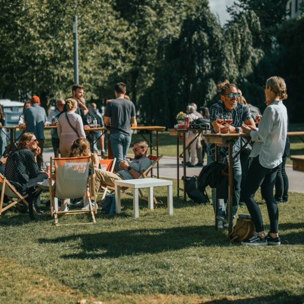 Personen in Liegestühlen und an Stehtischen auf einer Veranstaltung. © Personen in Liegestühlen und an Stehtischen auf einer Veranstaltung. ©